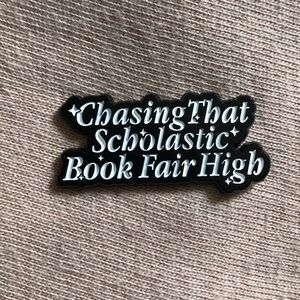 Chasing That Scholastic Book Fair High Enamel Pin